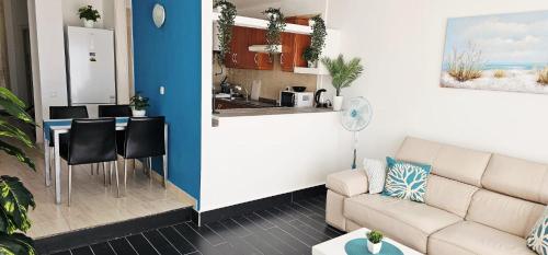a living room with a couch and a kitchen at Sunshine Beach Apartments in Adeje