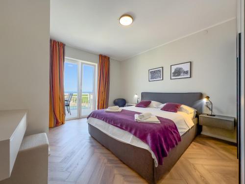 a bedroom with a large bed with a purple blanket at Cecilia Apartments - stunning sea views and relaxing Mediterranean getaway in Lun