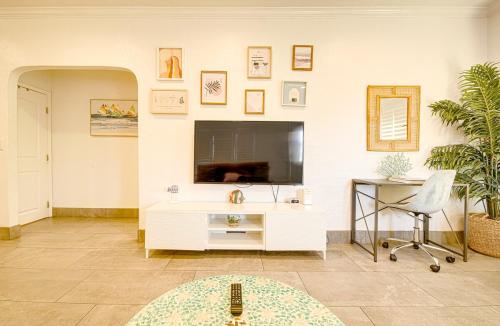 a living room with a television and a table and a chair at 1000#1 Contemporary Home w/ Parking, Grill, & AC! in Newport Beach