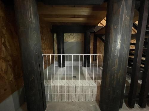 an attic room with a staircase and wooden beams at Guesthouse PITIN - Vacation STAY 29132v in Shikokuchuo