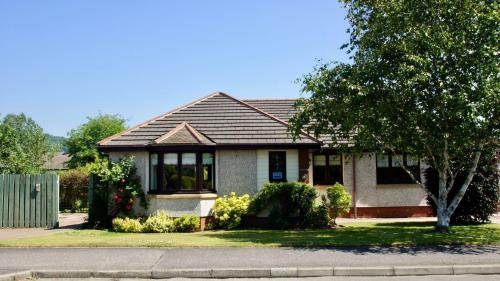 a house with a tree in front of it at Tomanour in Comrie