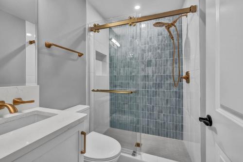 um banheiro com chuveiro, vaso sanitário e pia em The Wright View by Sea Scape Properties em Wrightsville Beach