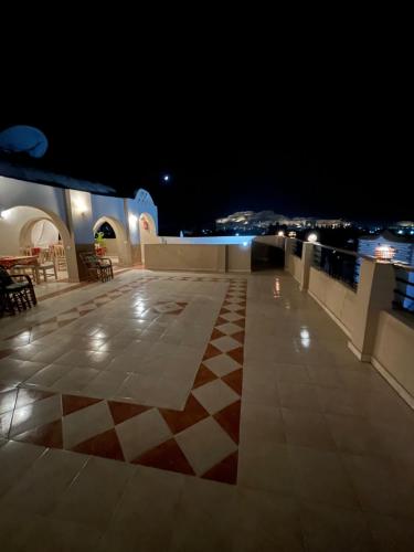 a rooftop patio at night with a checkered floor at RK Hotel in Luxor