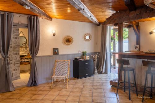 a kitchen with a counter and chairs in a room at Chalet du Rhin, le coin de Mut en Alsace proche Europa Park in Muttersholtz