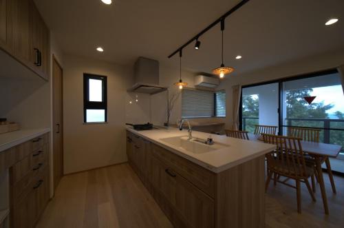 a kitchen with a sink and a table with chairs at LAGUNA OKINAWA Beachfront - Vacation STAY 30553v in Yaka