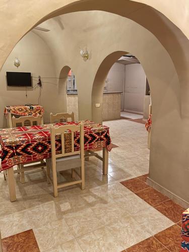 a dining room with a table and a tv at RK Hotel in Luxor