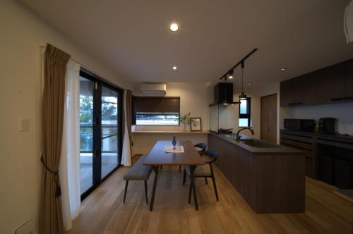a kitchen with a wooden table and a dining room at LAGUNA OKINAWA Beachfront - Vacation STAY 30548v in Yaka
