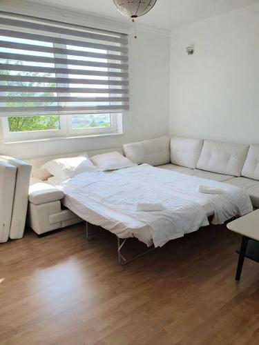 a large white bed in a room with a window at Small Hill Apartments in Sarajevo