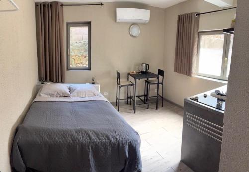 une chambre avec un lit et une table dedans dans l'établissement Maison La Terre du Midi à Sérignan, à Sérignan