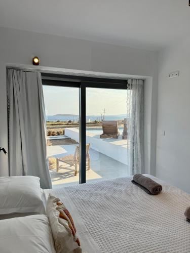 a white bedroom with a bed and a large window at Faragas Hill in Angairiá