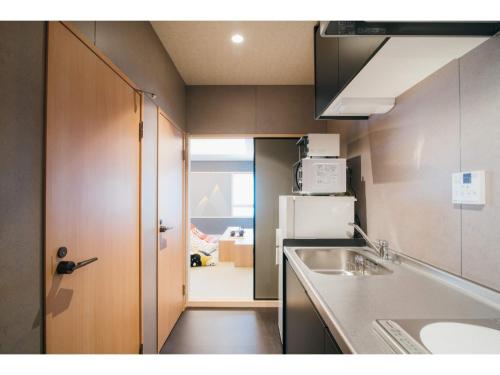 a small kitchen with a sink and a refrigerator at Isizue Tabine - Vacation STAY 31765v in Kanazawa