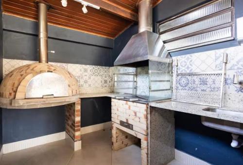 a large kitchen with a large oven in the wall at Vista Mar em Búzios Praia de Geribá c/ Piscina in Búzios
