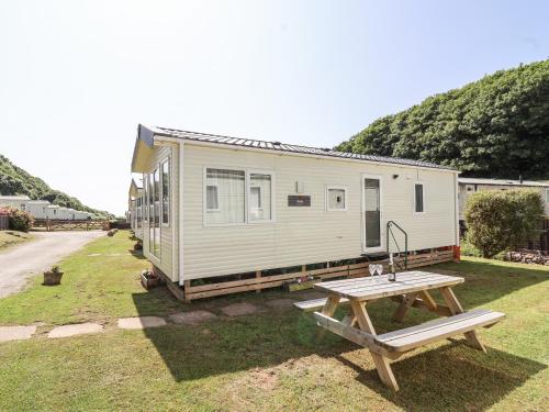 a tiny house with a picnic table in front of it at Caravan 7 in Plymouth