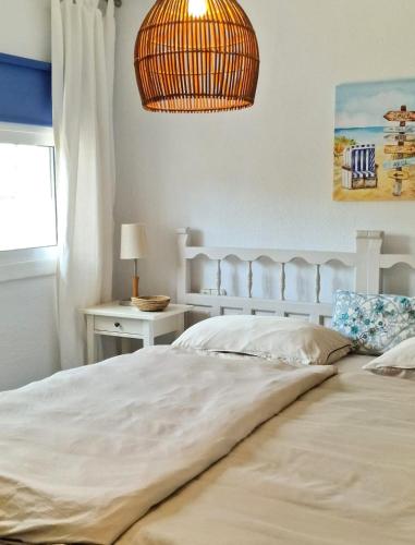 a bedroom with a large white bed and a lamp at Villa de Gracia Casa 3 in Tordera