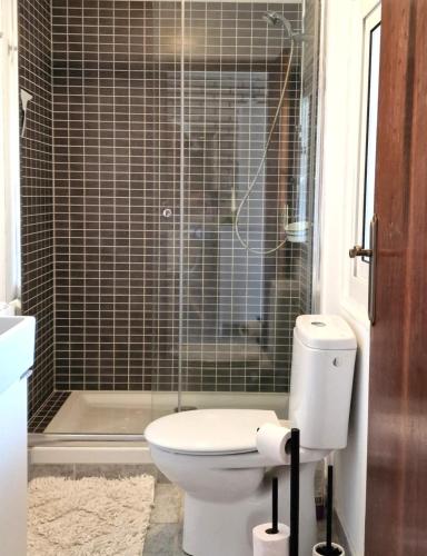 a bathroom with a toilet and a glass shower at Villa de Gracia Casa 3 in Tordera