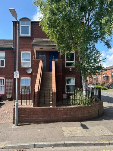 a brick house with a fence in front of it at Tourist board certified Super city centre apartment with free parking in Belfast
