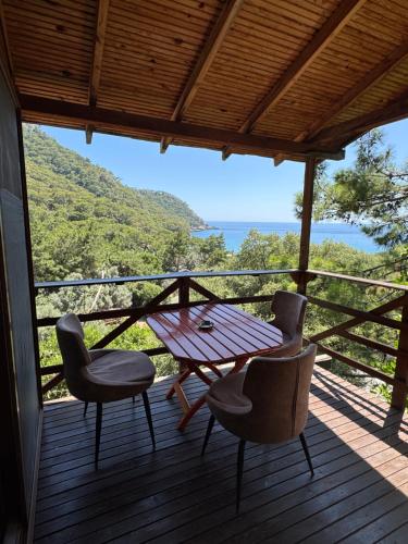 a table and chairs on a deck with a view at Lilith Pan Bungalows in Fethiye
