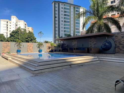 a swimming pool in a city with buildings at Flat Crystal Place 209 in Goiânia