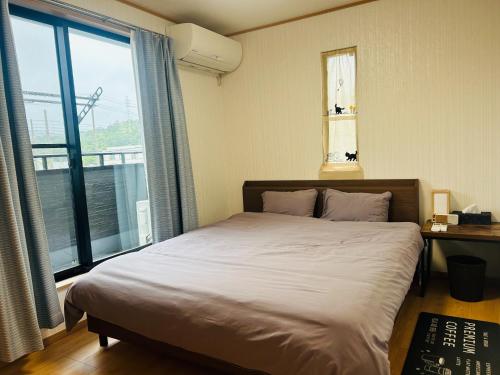 a bedroom with a bed and a large window at The Ritz Okinawa Kise II - Vacation STAY 36742v in Nago