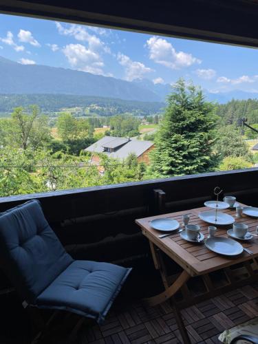 a table and chairs in front of a large window at Haus Silverfern in Förolach