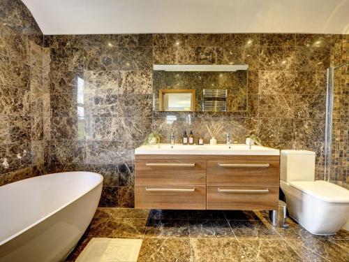 a bathroom with a tub and a sink and a toilet at The Farm House in Richmond