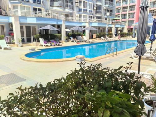 a swimming pool with chairs and umbrellas in a building at Sunny Dream Family Apartment in Sunny Beach