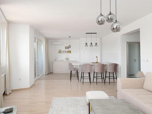 sala de estar blanca y cocina con mesa y sillas en Skyline Residence Sarajevo Tower, en Sarajevo