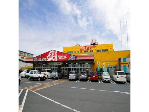 a parking lot with cars parked in front of a building at Hotel Tetora Hachinohe - Vacation STAY 46446v in Hachinohe