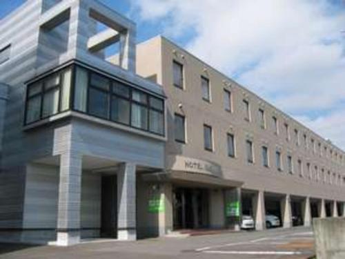 a large building with a parking lot in front of it at Hotel Tetora Hachinohe - Vacation STAY 46446v in Hachinohe
