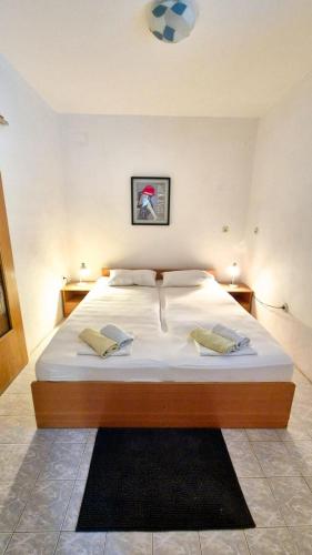 a bedroom with a large white bed with two pillows at Studio Apartmani Šehić in Krvavica