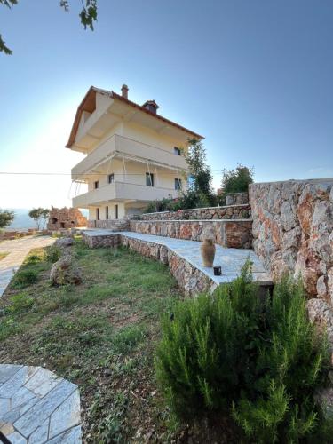a house with a stone wall and a building at Guest House Novaku 