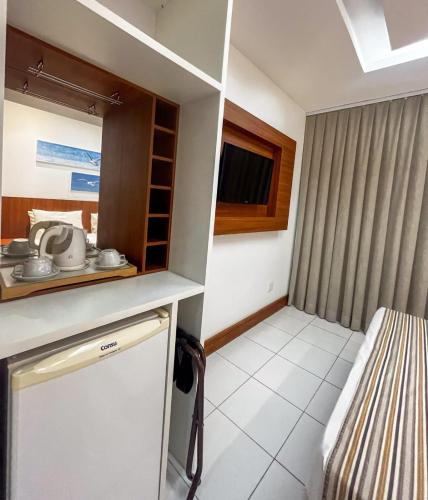 a small room with a kitchen and a bed at Hotel Paradiso del Sol in Cabo Frio