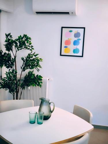 a white table with a pitcher and two glasses on it at Stylish Comfort in Mandelieu in Mandelieu-la-Napoule