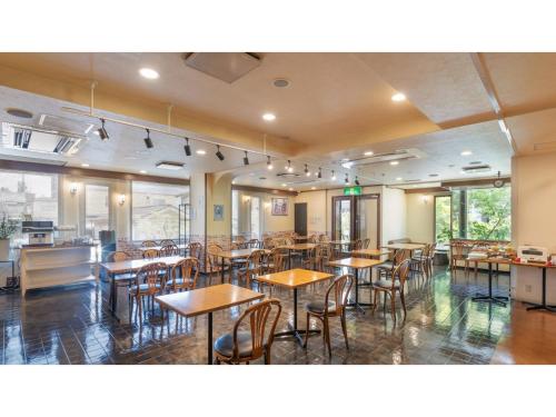 a dining room with tables and chairs and windows at Sun Hotel Fukuyama - Vacation STAY 53489v in Fukuyama