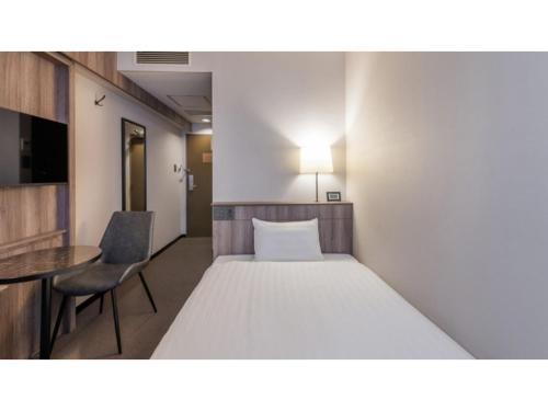 a hotel room with a bed and a table and a chair at Sun Hotel Fukuyama - Vacation STAY 53433v in Fukuyama