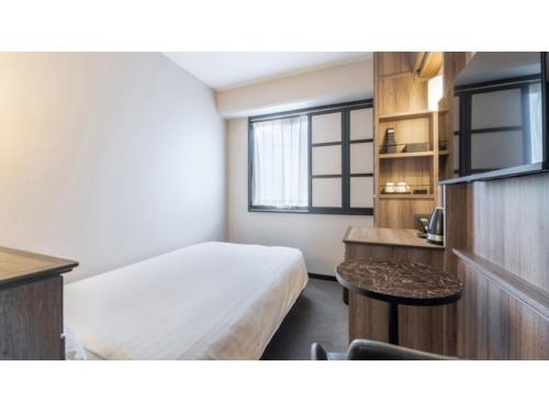 a hotel room with a bed and a window at Sun Hotel Fukuyama - Vacation STAY 53433v in Fukuyama