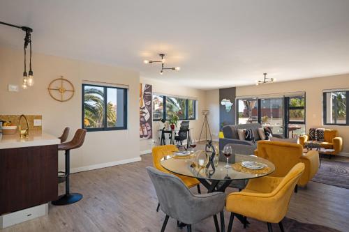 a living room with a table and yellow chairs at Knightsbridge Terrace in Cape Town