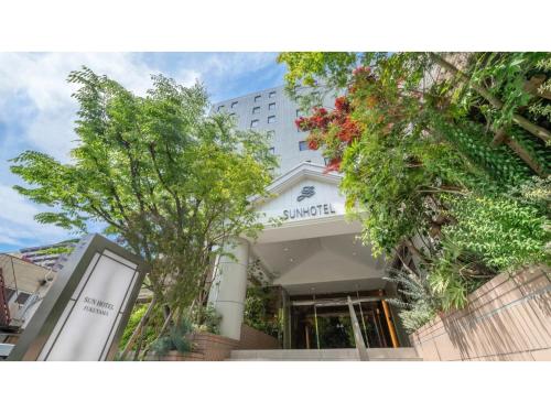 a white building with trees in front of it at Sun Hotel Fukuyama - Vacation STAY 53481v in Fukuyama