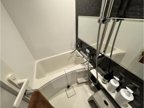 a white bathroom with a mirror and a sink at SAUNA HOTEL GIFU - Vacation STAY 48263v in Gifu