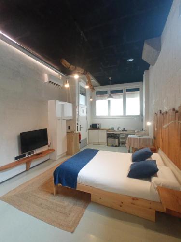 a large bedroom with a large bed and a kitchen at Itsaso Apartamentuak in Getaria
