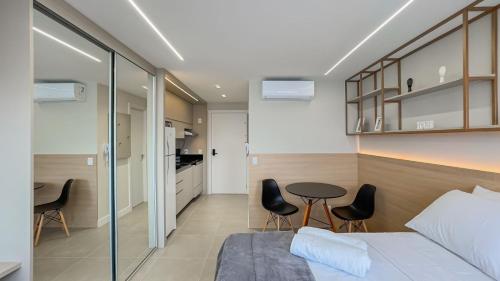 a bedroom with a bed and a table and chairs at GO Rio Branco by LikeHome in Porto Alegre