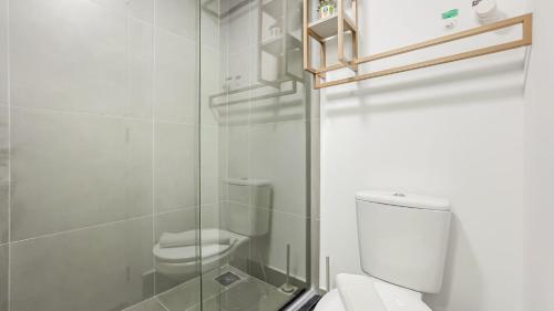 a white bathroom with a toilet and a shower at GO Rio Branco by LikeHome in Porto Alegre