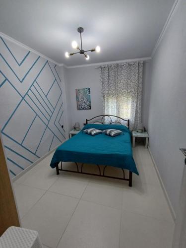 a bedroom with a bed with a blue blanket at Casa Chinook Sea View Homes-Porto Koufo in Porto Koufo