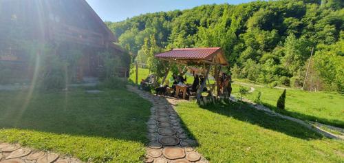 a group of people sitting under a gazebo in a field at Plav Riverside Village in Plav
