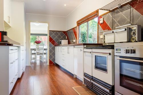 a large kitchen with white cabinets and appliances at Lynrose Place in Stanthorpe