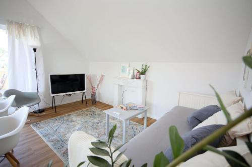 a living room with a couch and a tv at P-Hosting Kitten Manor im Kurort Bad Waldsee in Bad Waldsee
