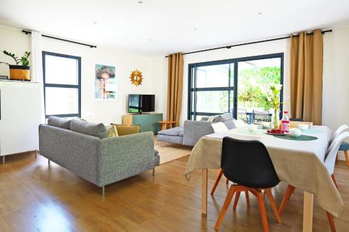 a living room with a table and chairs at Maison des Paradisiers - Welkeys in Le Crès