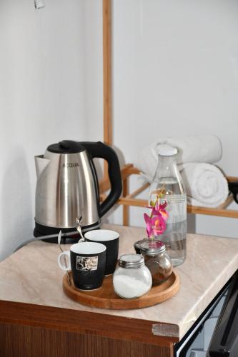 a counter with a coffee pot and cups on it at GuestHouse "Shtëpia ime" in Përmet