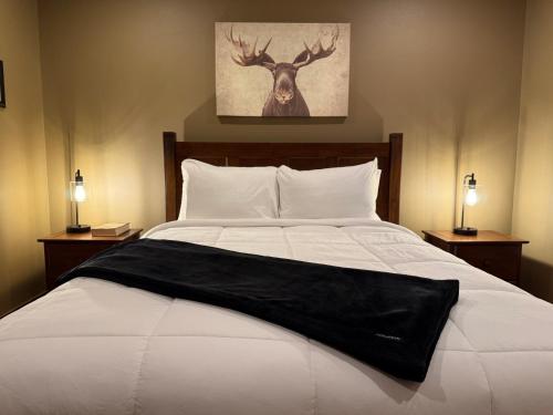 a bed with a black blanket on it with two lamps at 3BR Home - Near The Landing - Free Tickets Included - Cottonwood Cottage in Branson