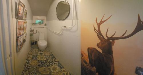 a bathroom with a toilet and a picture of a deer on the wall at Natuurhuisje Hoogeloon PMV in Hoogeloon